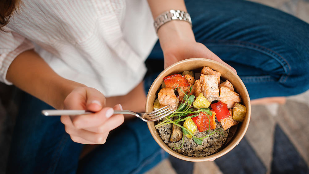 woman holding bowl of healthy food