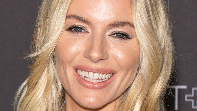 close up of actor Sienna Miller with a bold red lip 