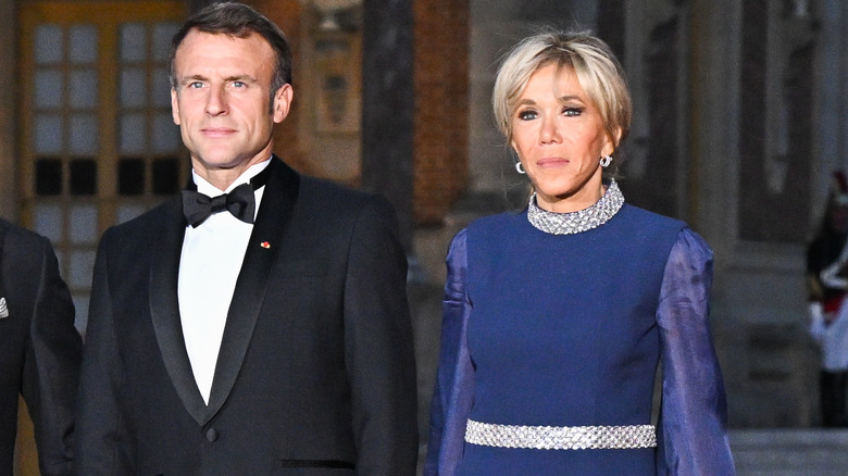 Emmanuel Macron and Brigitte Macron looking serious as they attend an event together