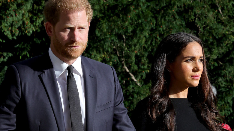 Prince Harry and Meghan Markle looking morbid