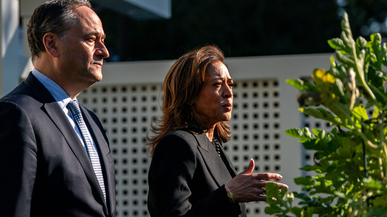 Kamala Harris and Doug Emhoff looking serious as Kamala addresses someone