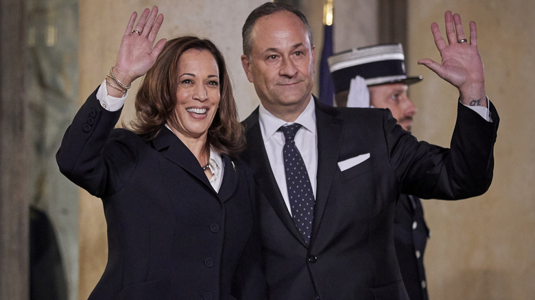 Kamala Harris and Doug Emhoff waving at a crowd