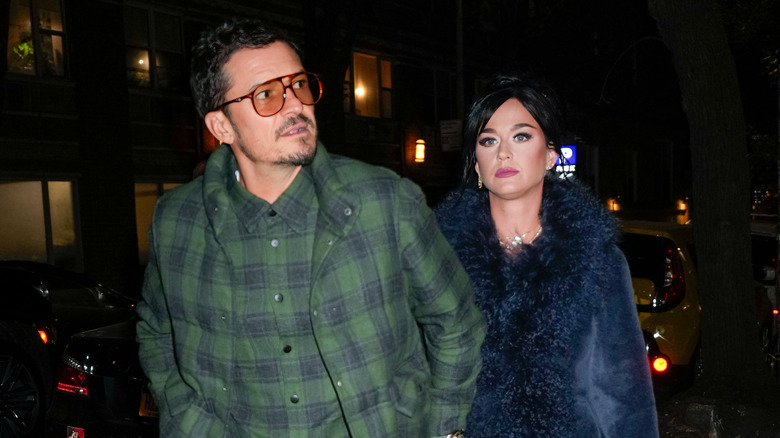 Katy Perry and Orlando Bloom walking out of a restaurant while looking downcast