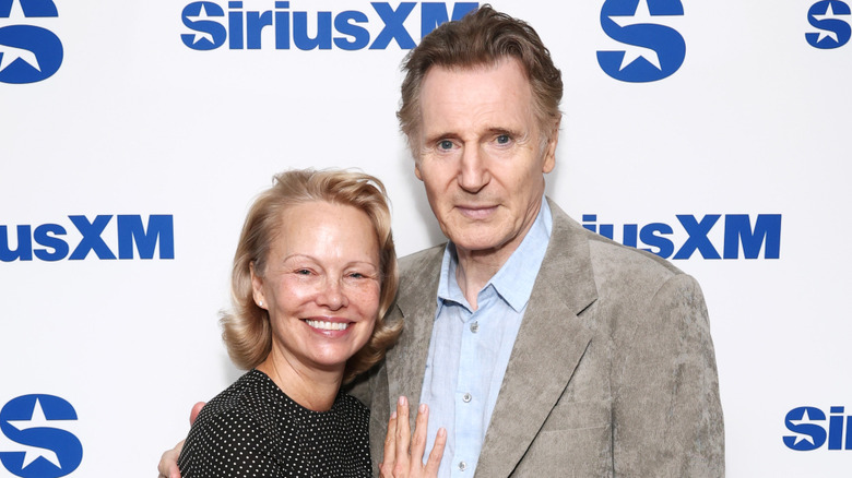 Pamela Anderson and Liam Neeson posing together on the red carpet