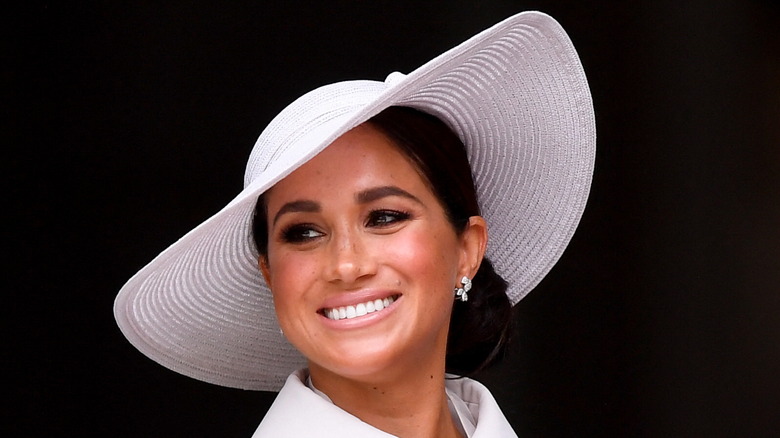 Meghan Markle smiling in a big hat