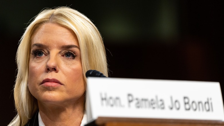Pam Bondi sitting down in a black blazer and white collared shirt at the Senate hearing for attorney general nomination.