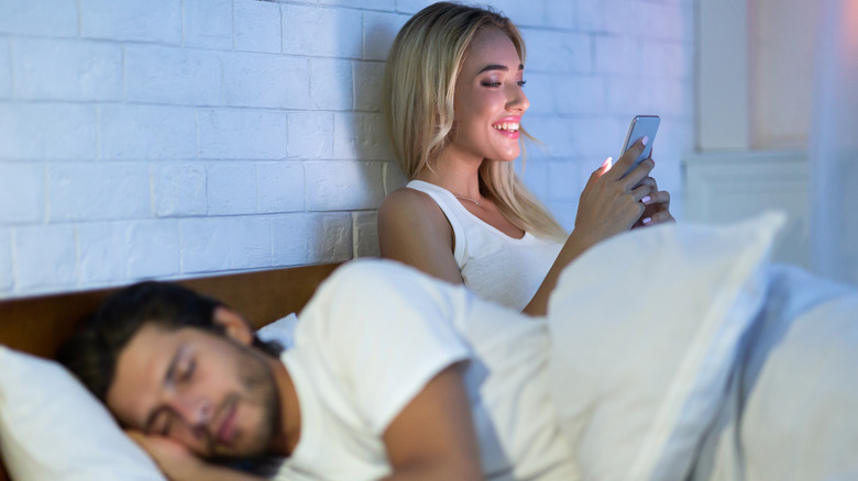 woman texting man asleep