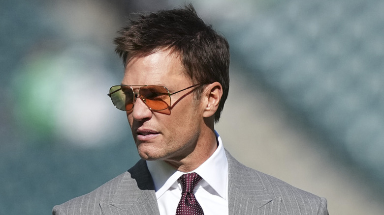 Tom Brady watching an NFL game from the sidelines