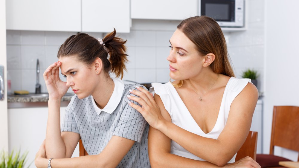 two women talking, one woman upset