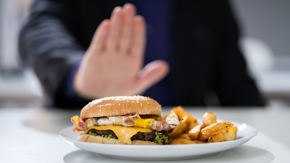 Hand refusing cheeseburger