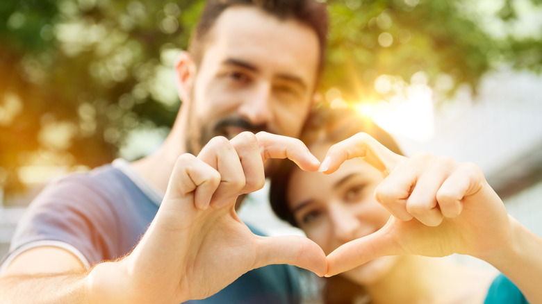 A couple making a heart with their hands