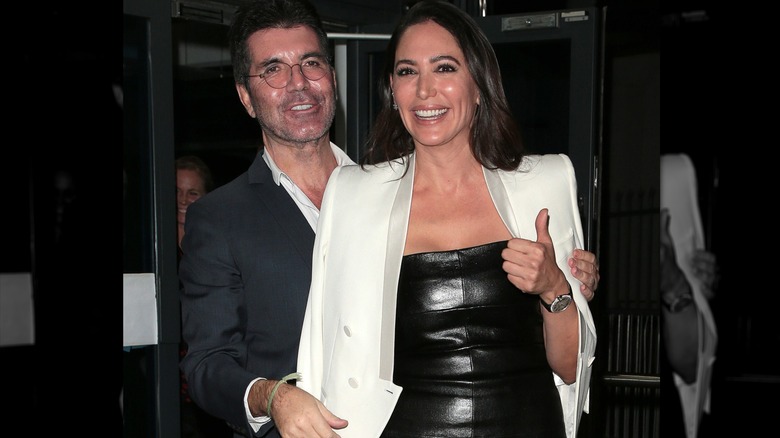 Simon Cowell and Lauren Silverman smiling while leaving LH2 studios