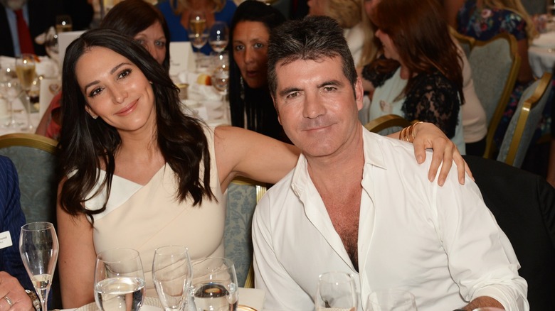 Lauren Silverman and Simon Cowell sitting down at the Health Lottery Tea Party at The Savoy