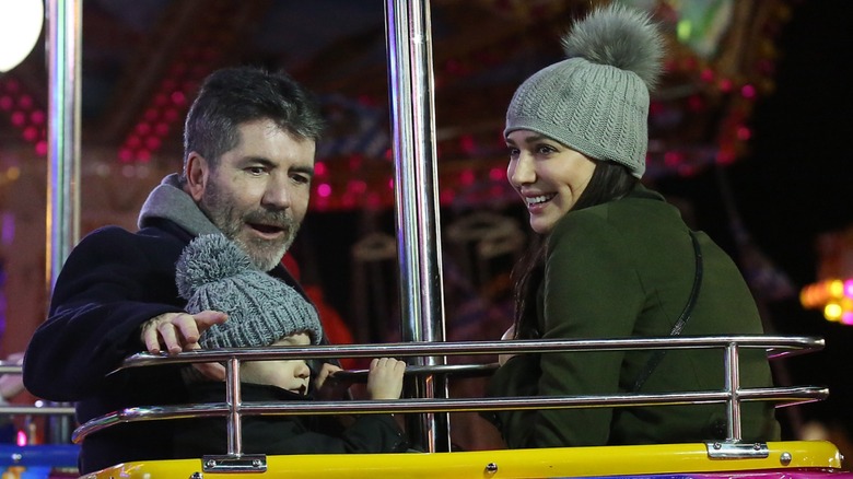 Simon Cowell, Eric Cowell, and Lauren Silverman on a ride at Hyde Park Winter Wonderland
