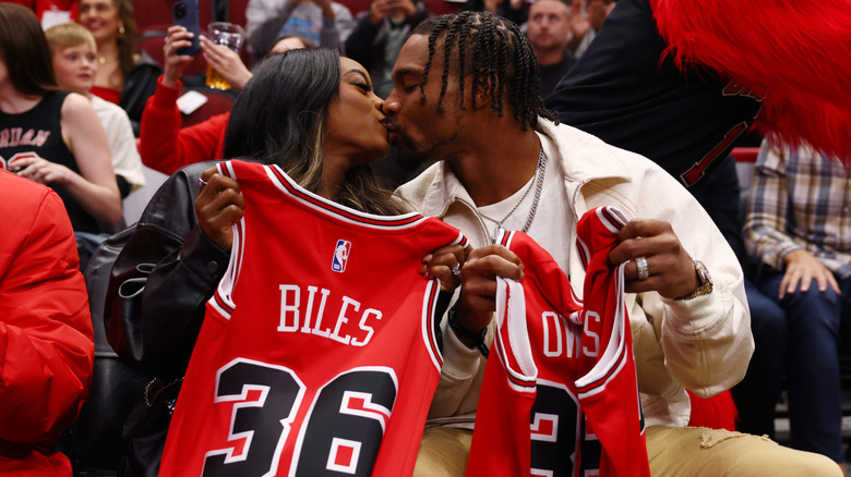 Simone Biles and Jonathan Owens kissing at a Chicago Bulls basketball game