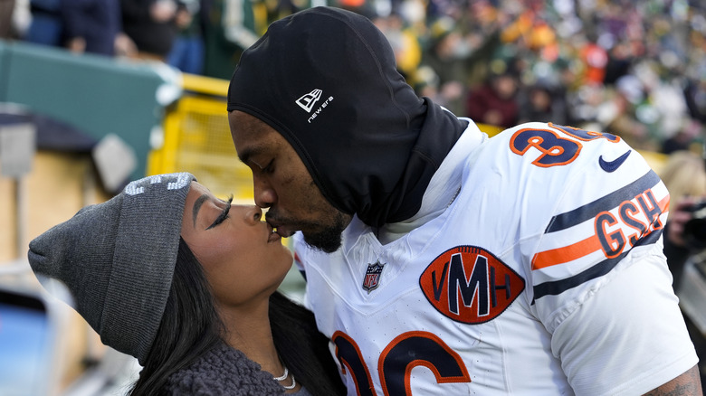 Simone Biles kissing Jonathan Owens at an NFL game