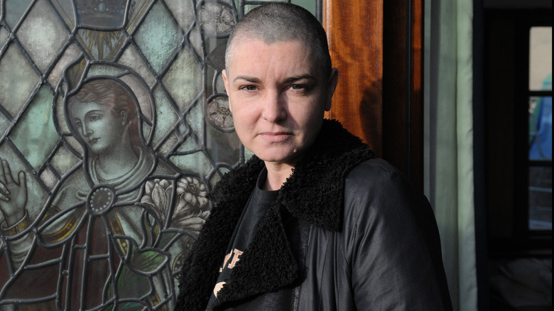 Sinead O'Connor posing next to window