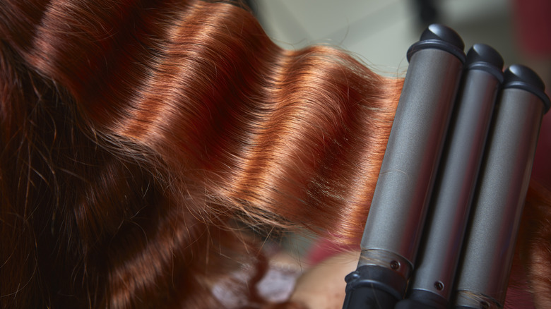 Woman with hair-waver tool 