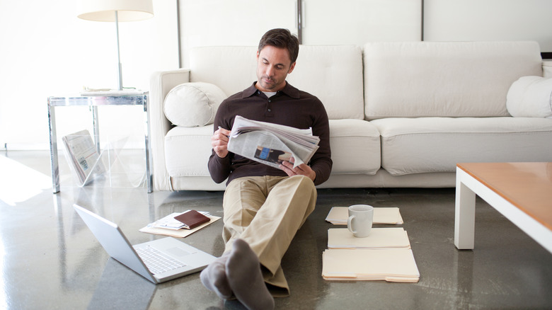 Man doing work while sitting on the floor