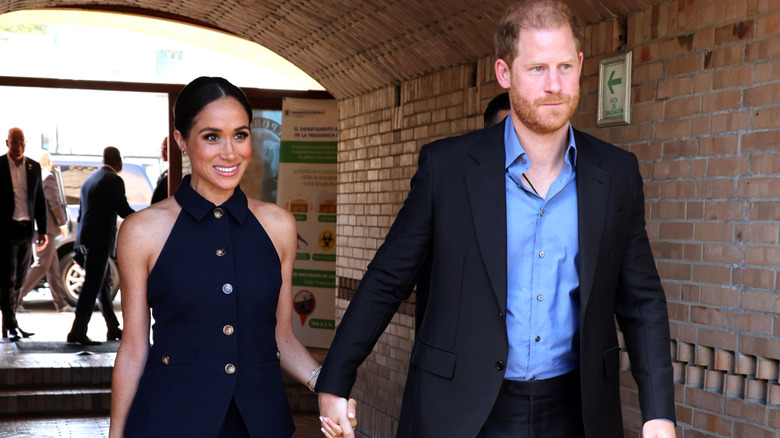 Prince Harry and Meghan Markle holding hands as they walk together