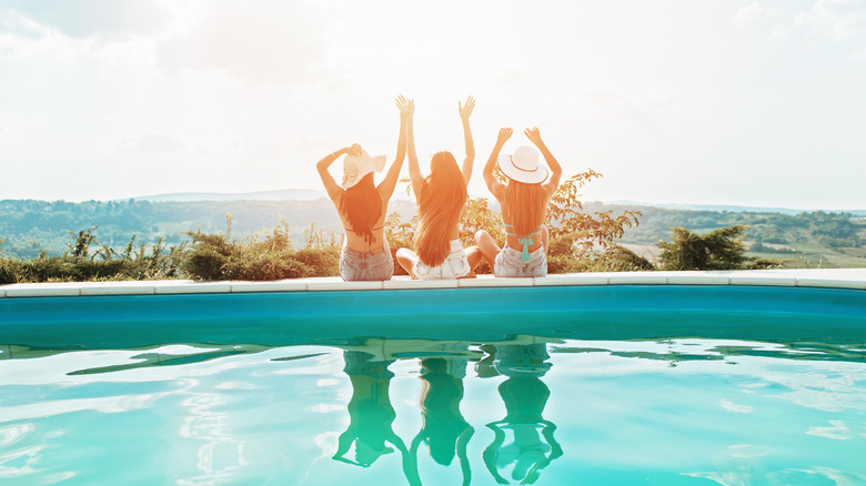 girls sitting by pool