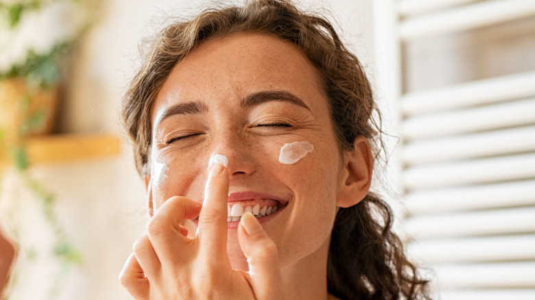 Woman applying face cream