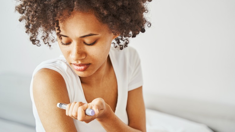 Woman injecting insulin