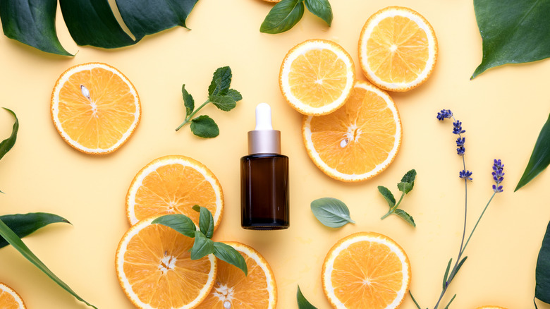 Vitamin C serum with sliced orange and herbs