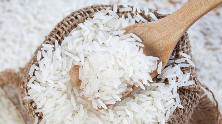 Wooden spoon of raw rice