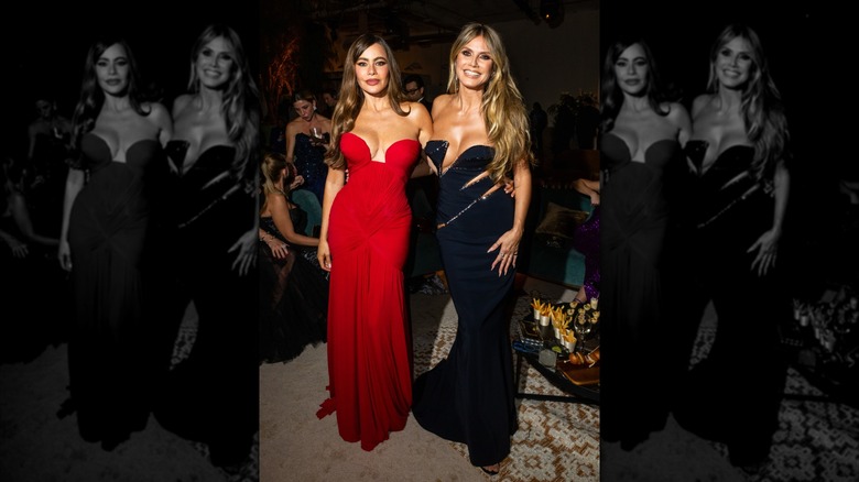 Sofía Vergara and Heidi Klum attend Netflix's Primetime Emmy event in 2024. Sofia (L) is wearing a red strapless dress with bust cutouts, and Heidi (R) is wearing a black sleeveless dress with cut-outs