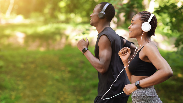 man and woman running with headphones on