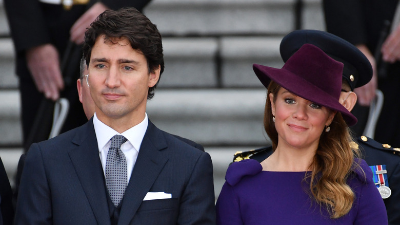 Sophie Grégoire smirking in a big purple hat next to Justin Trudeau