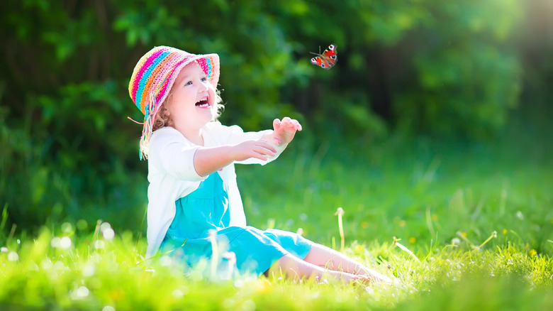Toddler girl playing with a butterfly