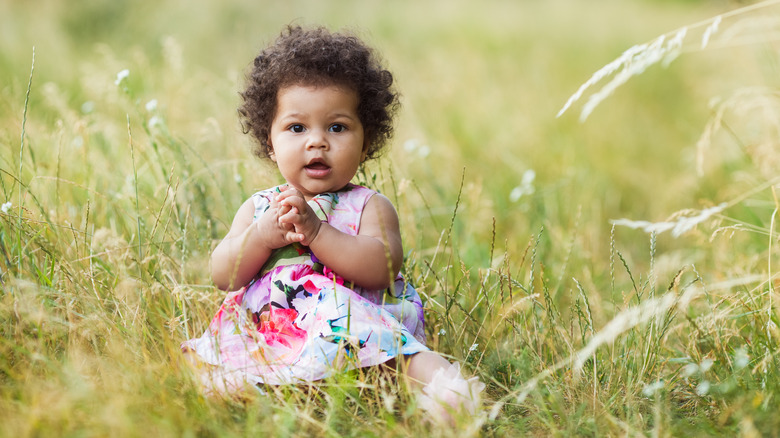 Baby girl sitting in field