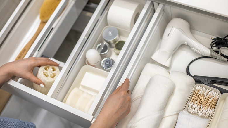 hands in organized bathroom drawer