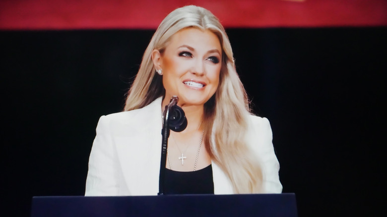 Erika Kirk at a podium in a white jacket