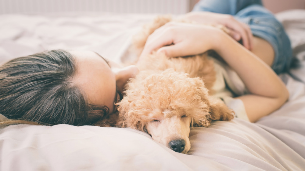 Woman cuddling dog