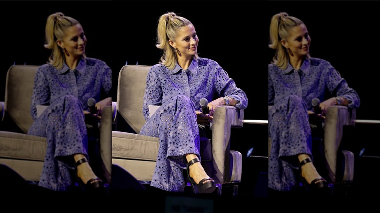 Laura Rutledge sitting in a gray chair, holding a microphone.