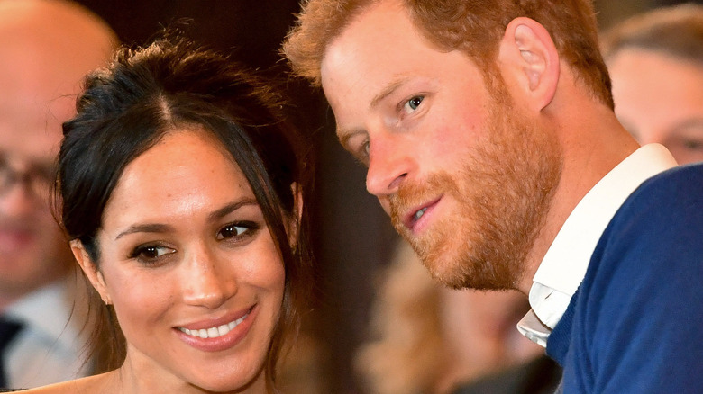 Meghan and Harry confer at an event
