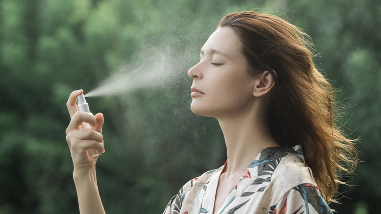 Woman using spray-on skincare