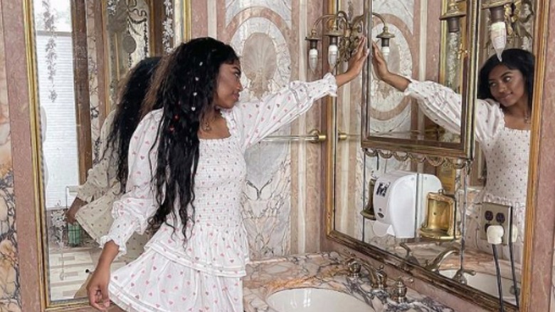 girl wearing frilly dress looking in mirror