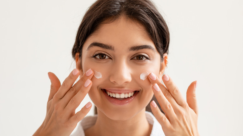 Woman applying face cream