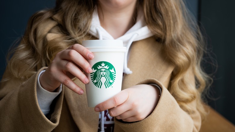 Woman holding Starbucks cup of coffee in hands