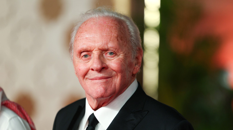 Anthony Hopkins smiling while posing on the red carpet