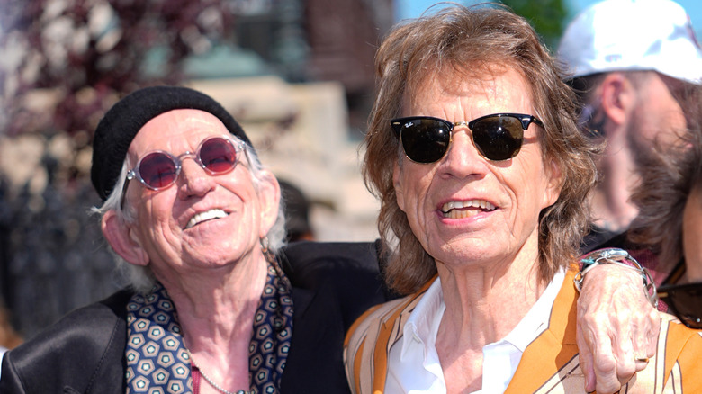 Keith Richards posing with Mick Jagger, both wearing sunglasses