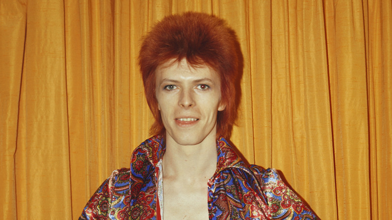 David Bowie smiling as Ziggy Stardust in 1970s