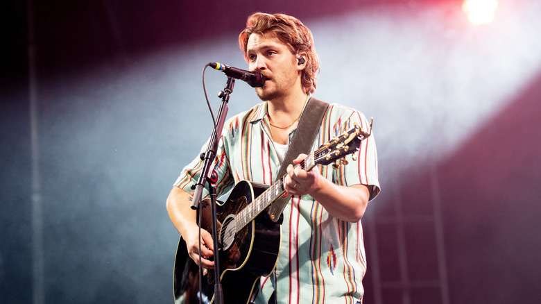 Luke Grimes singing and playing guitar on stage