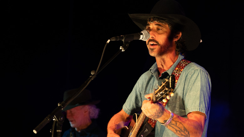 Ryan Bingham singing and playing guitar on stage
