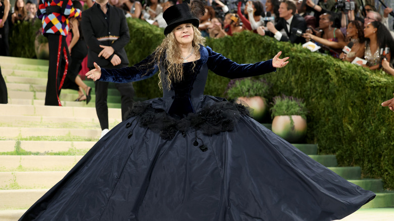 Stevie Nicks posing while wearing large down and top hat at the 2026 Met Gala