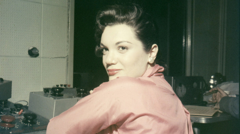 Connie Francis looking over her shoulder in a pink blouse